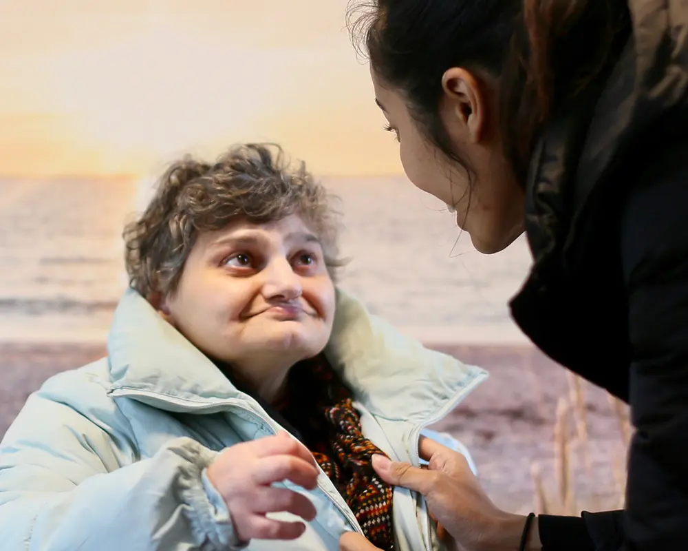 Eine Bewohnerin schaut mit einem interessierten Gesichtsausdruck ihre Betreuerin an.